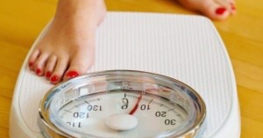 10975843 - the feet of a woman standing on bathroom scales to turn