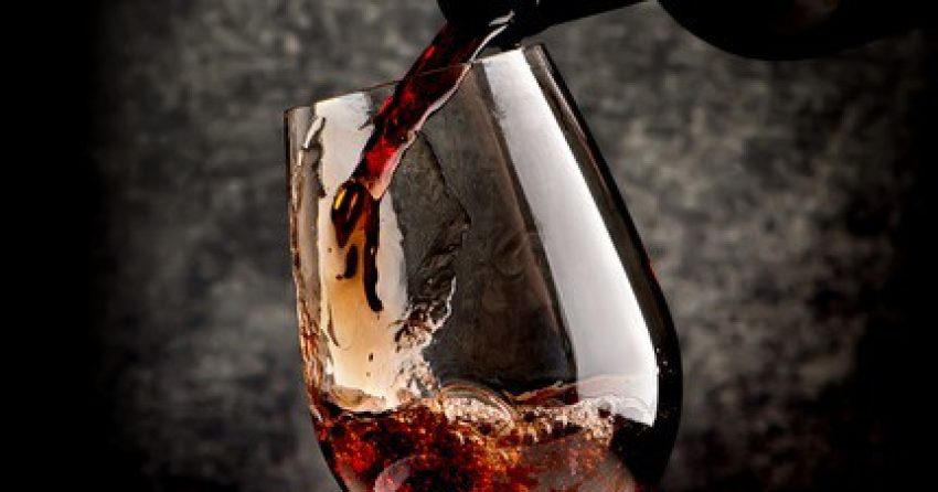 43817394 - wine pouring in wineglass on a black background