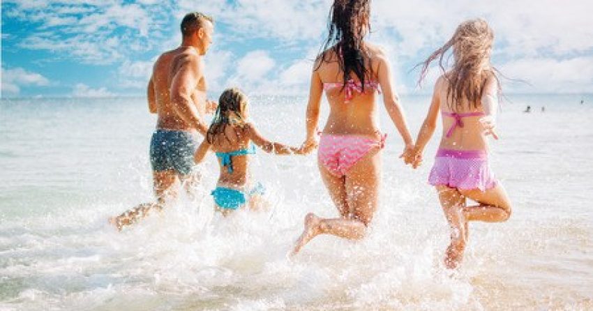 53464350 - happy family having fun on the beach. they with holding hands running and splashing in the sea.